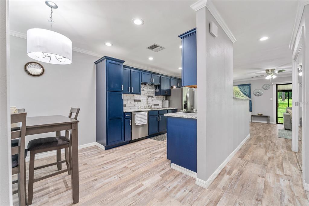 19660 Southwest 83rd Place Road, Unit C13 Dunnellon, FL 34432 - Photo 7 of 52 a kitchen with kitchen island stainless steel appliances a table chairs refrigerator and microwave