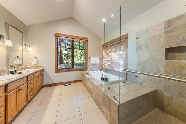 a spacious bathroom with a tub sink and mirror