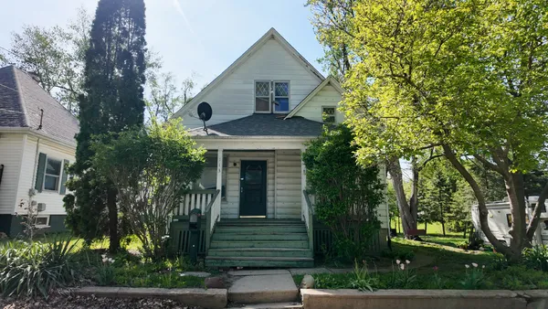 a front view of a house with a garden