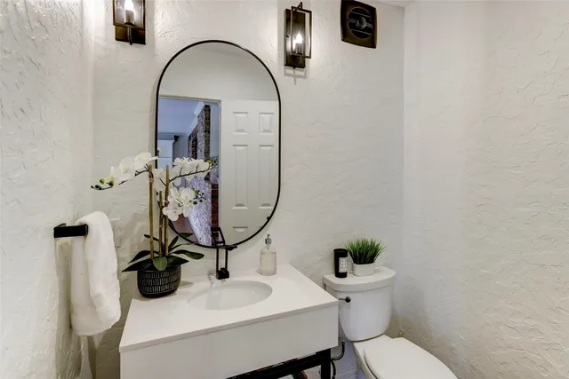 a bathroom with a sink toilet and mirror