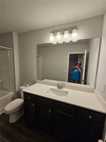 a bathroom with a sink vanity mirror and toilet