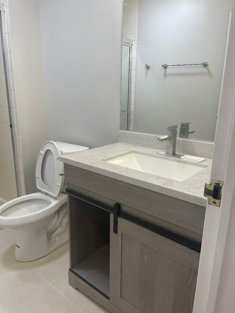 3801 Appian Way, Unit 302 Glenview, IL 60025 - Photo 11 of 16 a bathroom with a granite countertop toilet sink and mirror