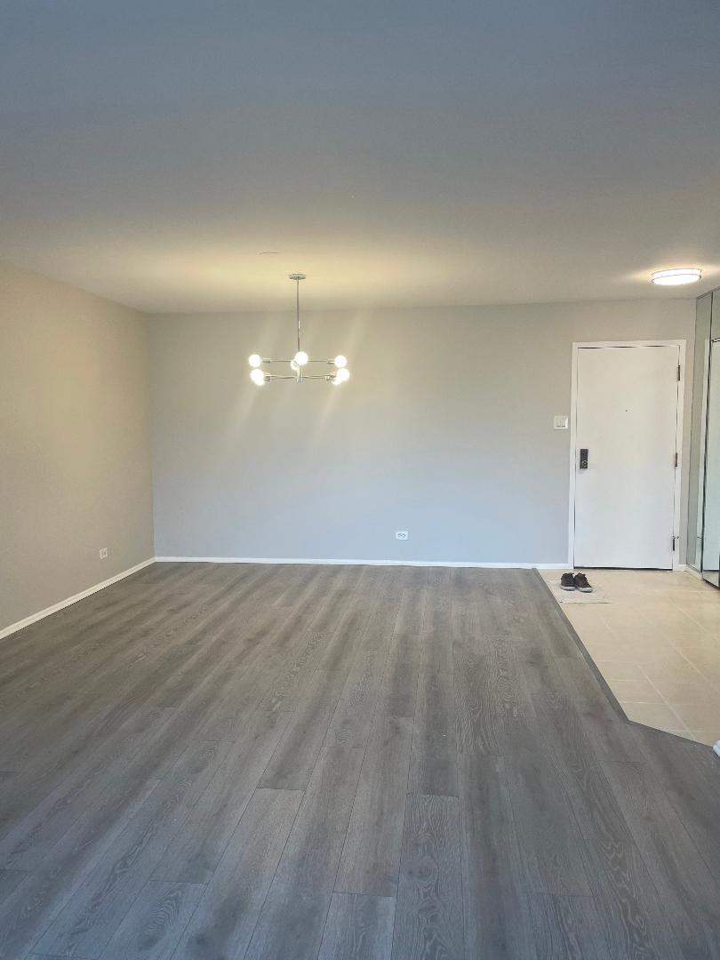 3801 Appian Way, Unit 302 Glenview, IL 60025 - Photo 2 of 16 an empty room with wooden floor and windows