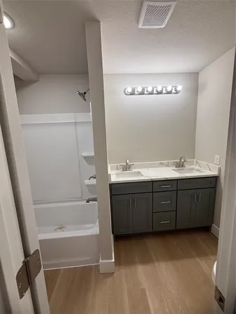 a bathroom with a tub sink and mirror