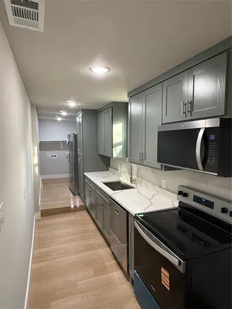 a large kitchen with a stove and a refrigerator