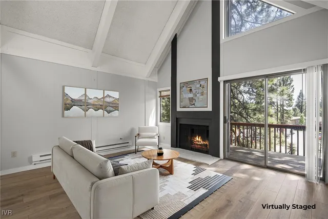 a living room with furniture a large window and a fireplace