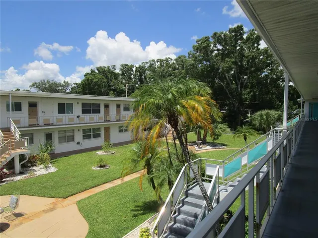 a view of a house with backyard and sitting area
