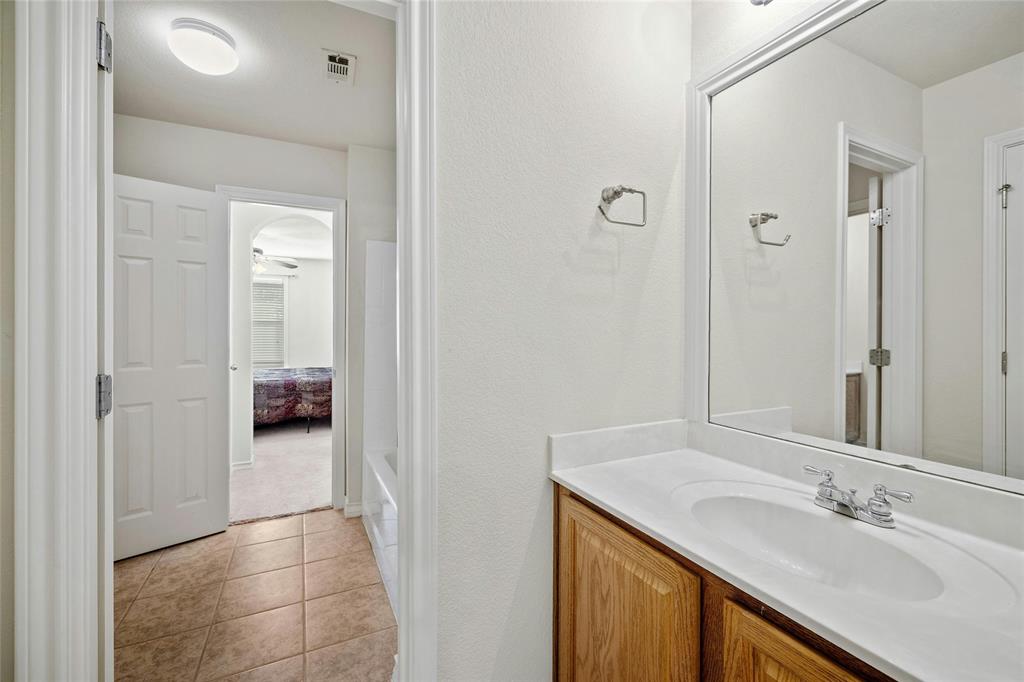2603 White Stallion Way Leander, TX 78641 - Photo 24 of 38 a en suite bathroom with a granite countertop sink and a mirror