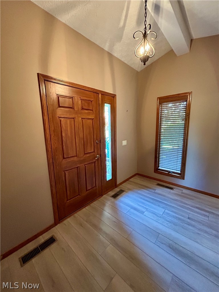 8763 Timber Edge Drive North Ridgeville, OH 44039 - Photo 22 of 40 Entrance foyer with a notable chandelier, wood-type flooring, and vaulted ceiling with beams
