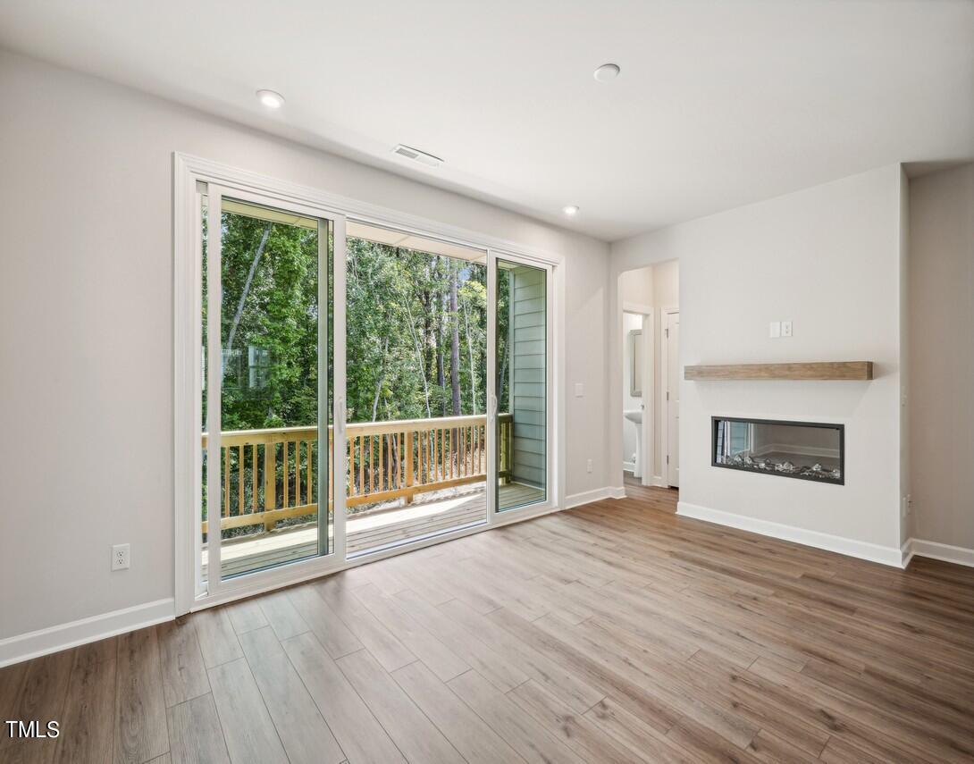 4816 Cypress Tree Lane Raleigh, NC 27612 - Photo 3 of 15 a view of an empty room with wooden floor and a window