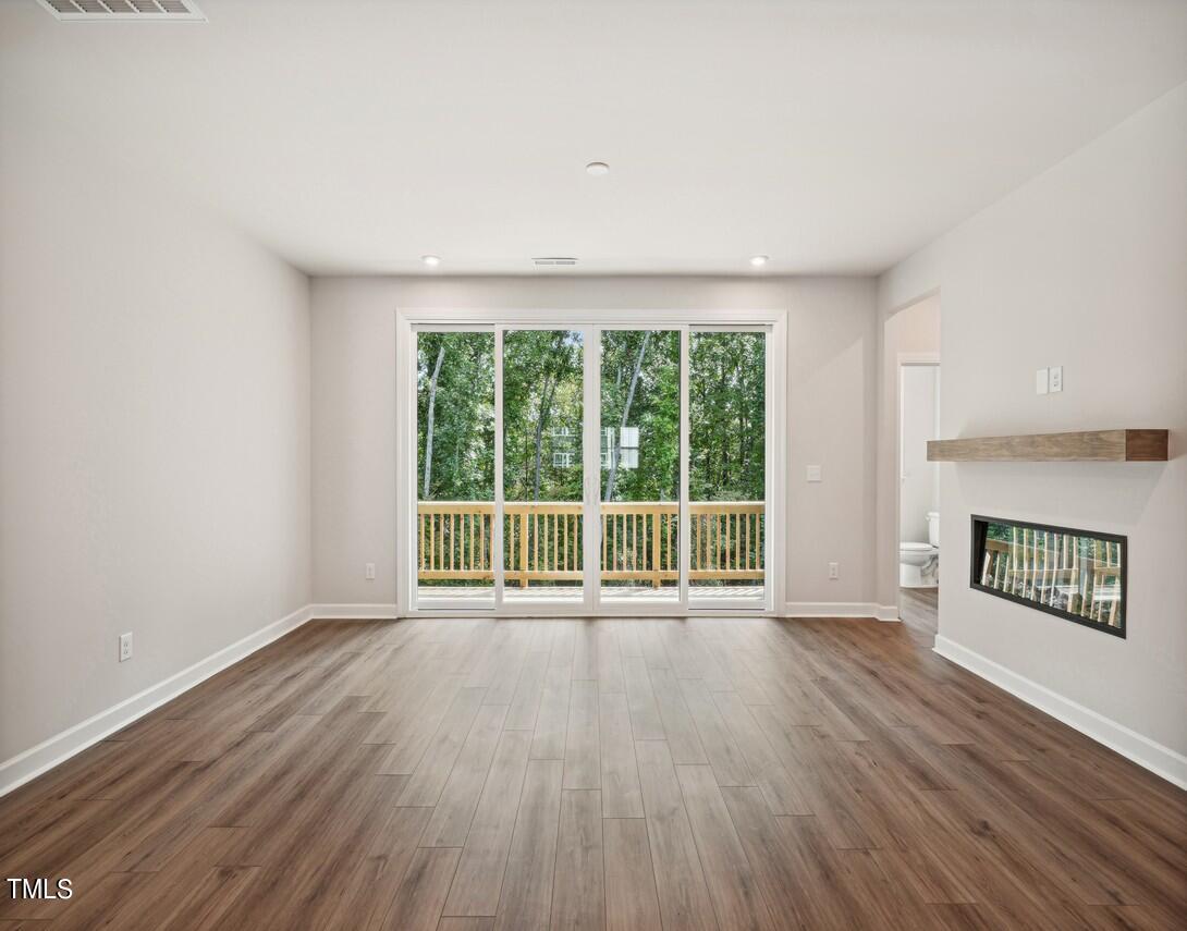 4816 Cypress Tree Lane Raleigh, NC 27612 - Photo 4 of 15 an empty room with wooden floor and windows