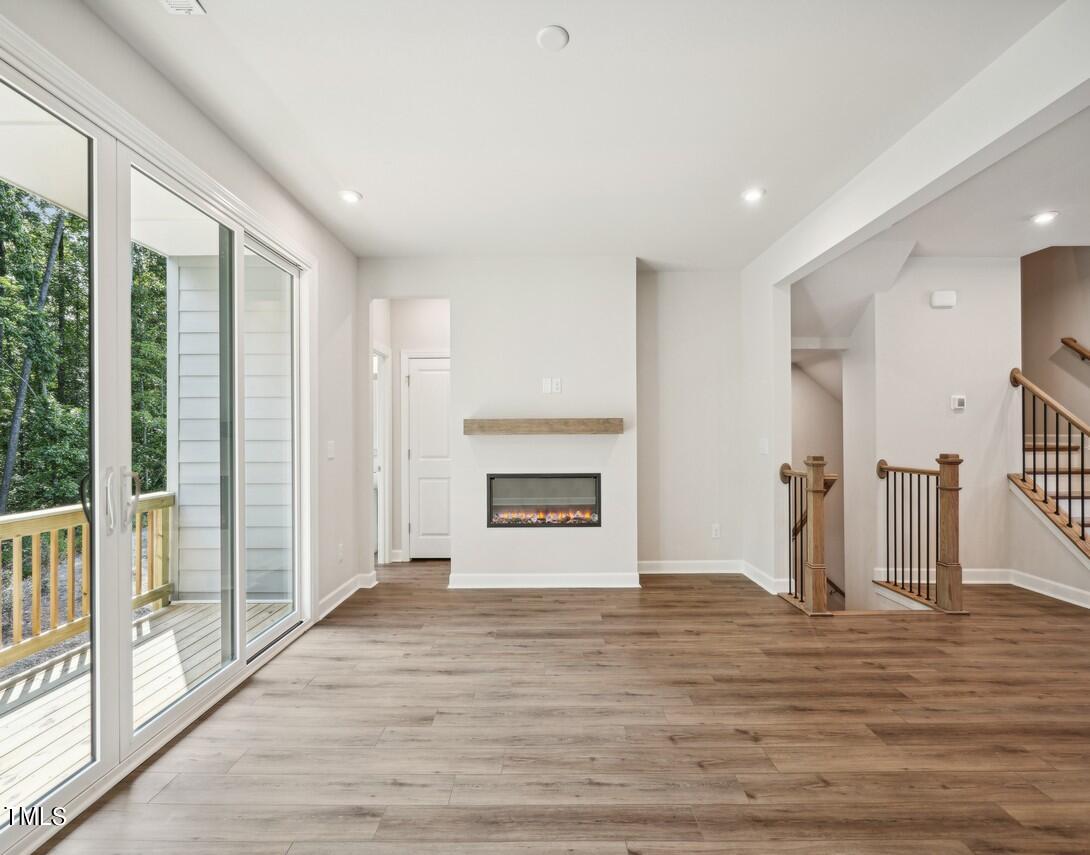 4816 Cypress Tree Lane Raleigh, NC 27612 - Photo 8 of 15 a view of empty room with wooden floor and fireplace