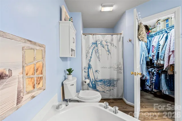 a bathroom with a toilet sink and shower curtain