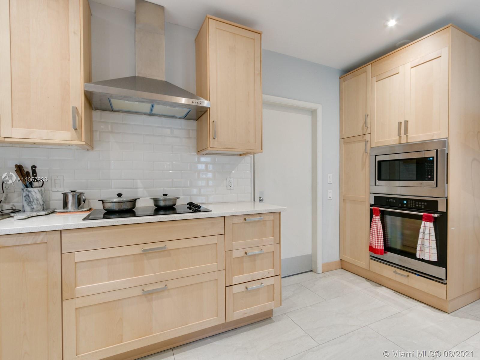 4708 Alton Road Miami Beach, FL 33140 - Photo 2 of 38 a kitchen with stainless steel appliances granite countertop a sink a stove and a microwave