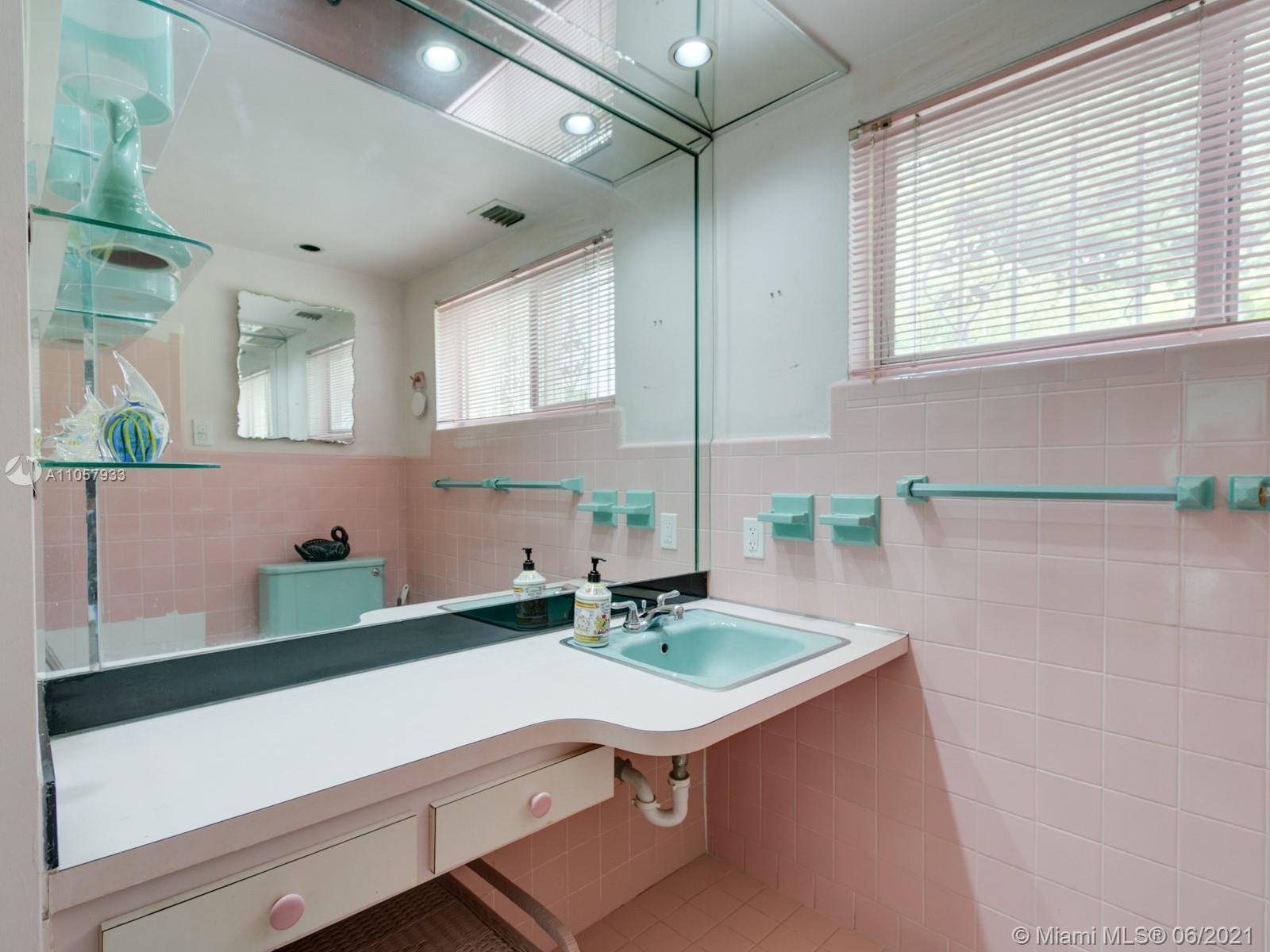 4708 Alton Road Miami Beach, FL 33140 - Photo 16 of 38 a bathroom with a sink a mirror and a bathtub