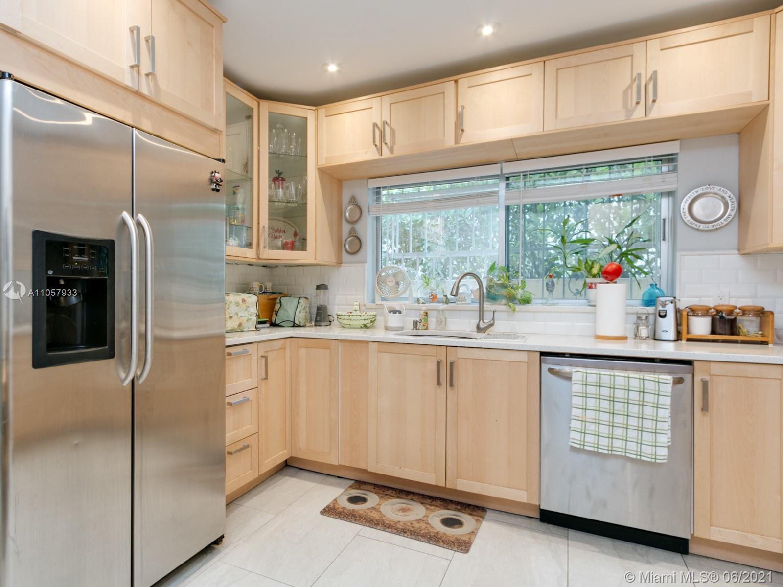 4708 Alton Road Miami Beach, FL 33140 - Photo 18 of 38 a kitchen with stainless steel appliances granite countertop a refrigerator and a sink