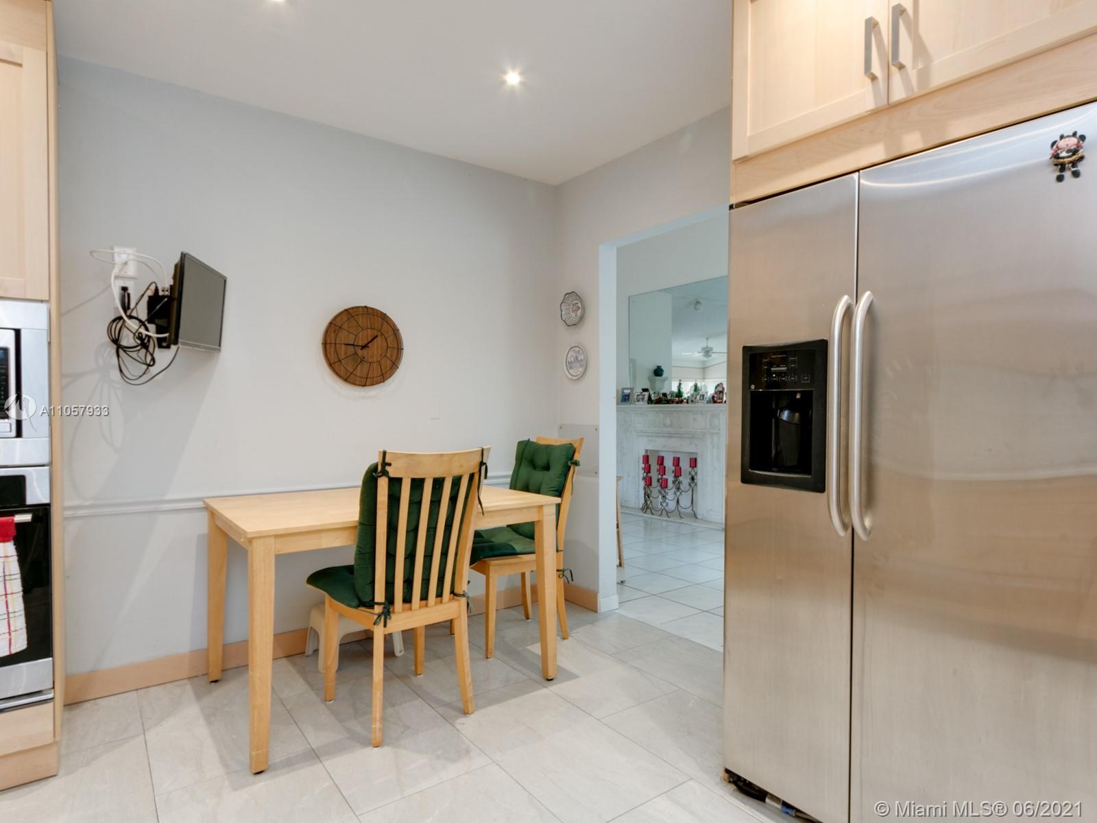 4708 Alton Road Miami Beach, FL 33140 - Photo 19 of 38 a kitchen with a refrigerator and chairs