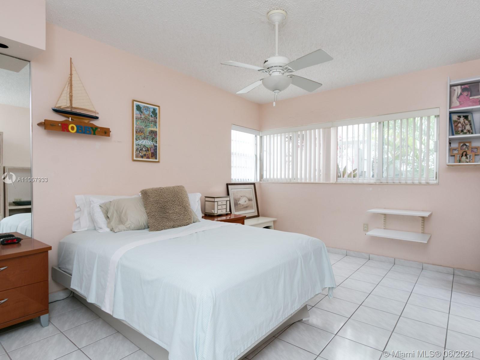 4708 Alton Road Miami Beach, FL 33140 - Photo 3 of 38 a bedroom with a large bed and a chandelier