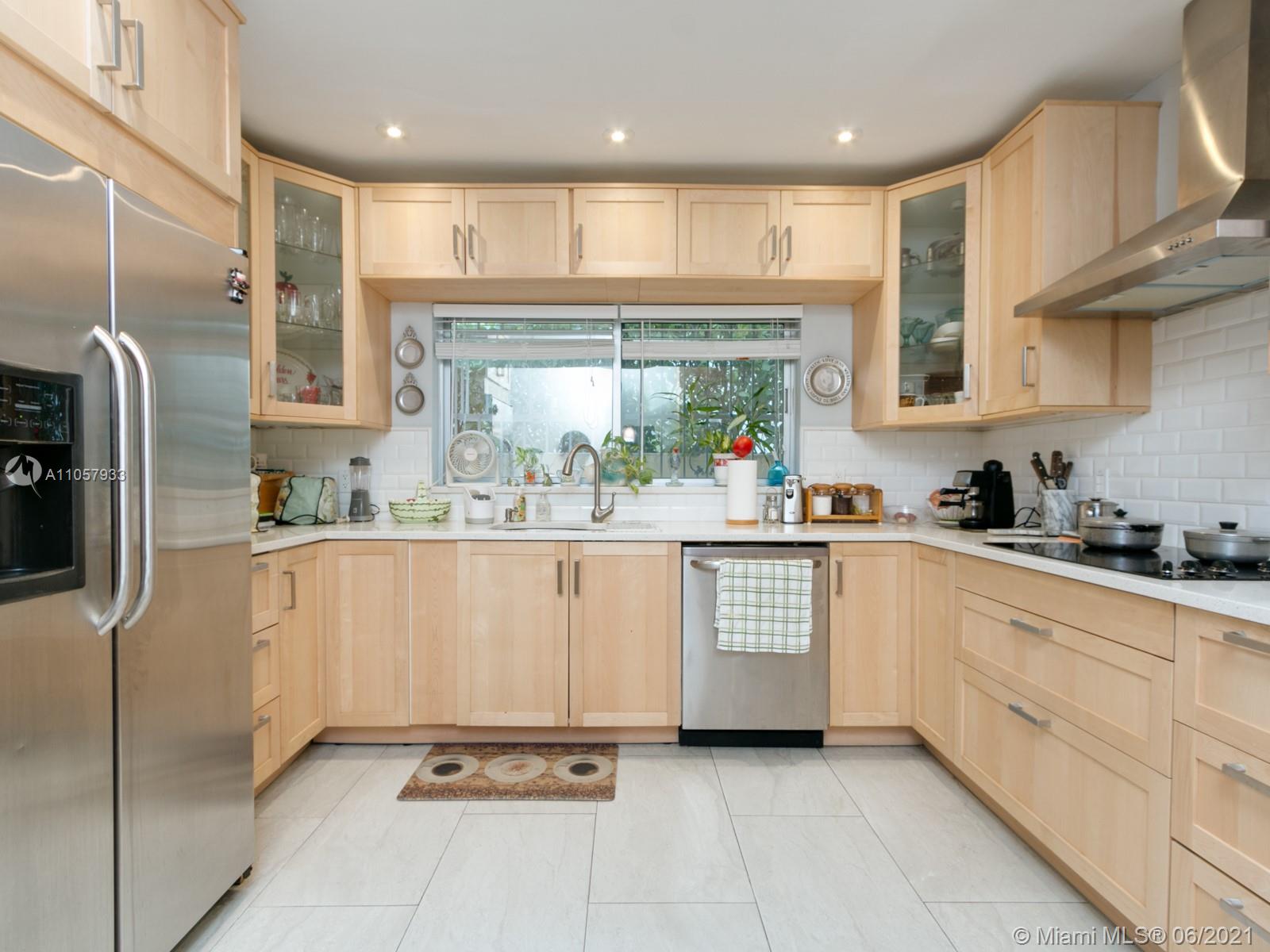 4708 Alton Road Miami Beach, FL 33140 - Photo 21 of 38 a kitchen with stainless steel appliances granite countertop a refrigerator sink and cabinets