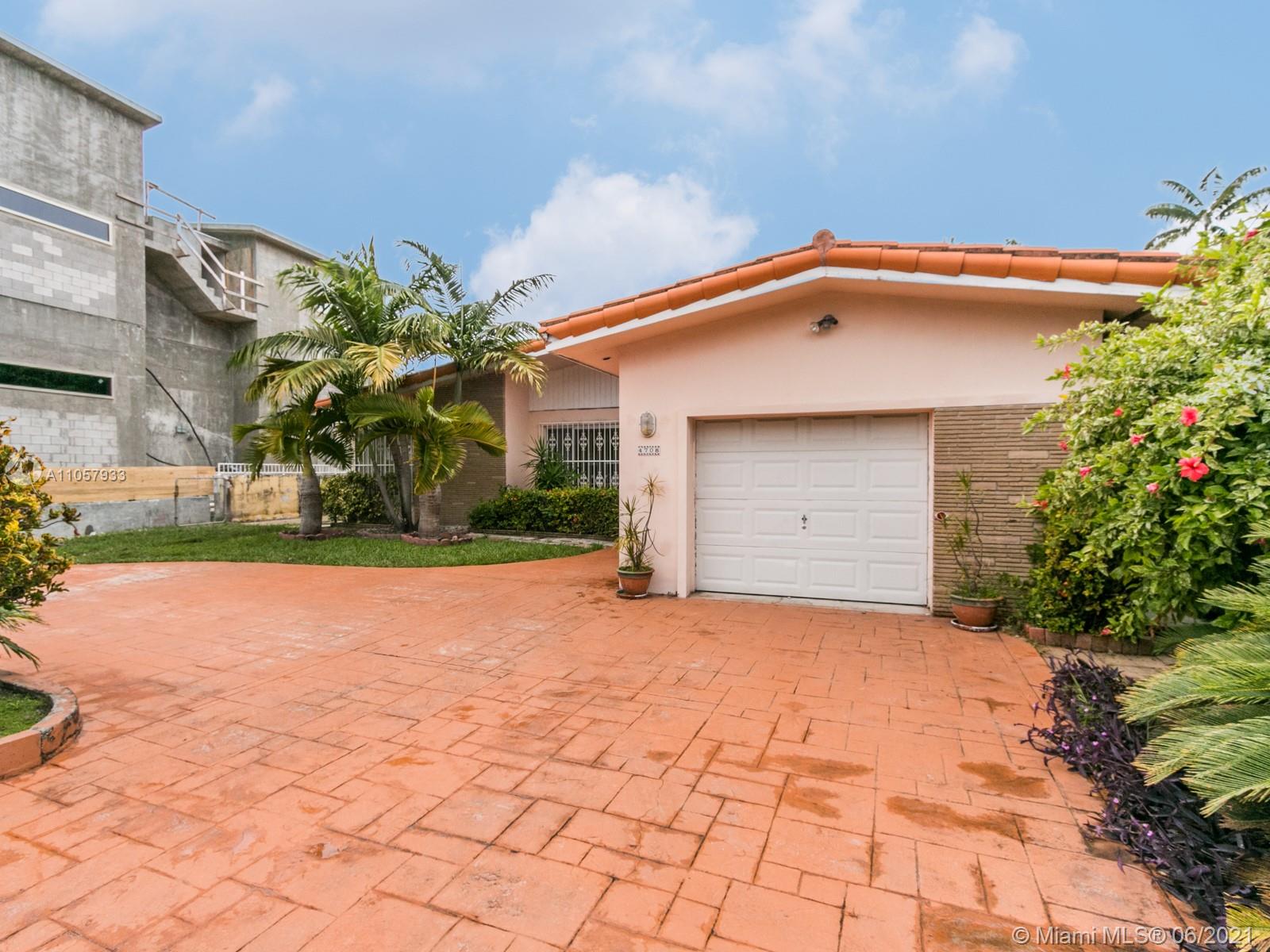 4708 Alton Road Miami Beach, FL 33140 - Photo 22 of 38 a front view of a house with a yard and garage