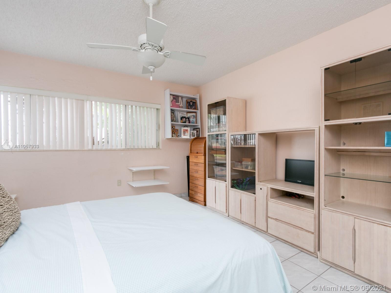 4708 Alton Road Miami Beach, FL 33140 - Photo 5 of 38 a bedroom with a large bed and a flat tv screen