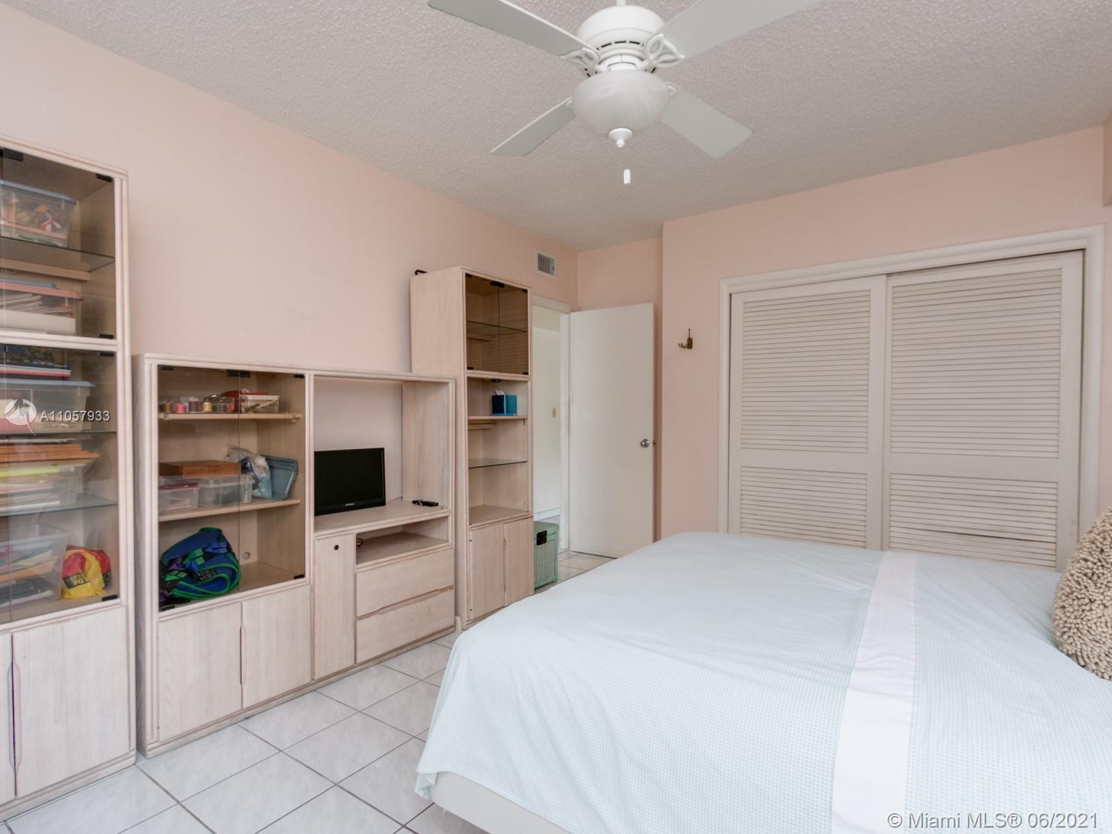 4708 Alton Road Miami Beach, FL 33140 - Photo 7 of 38 a large white kitchen with cabinets and stainless steel appliances