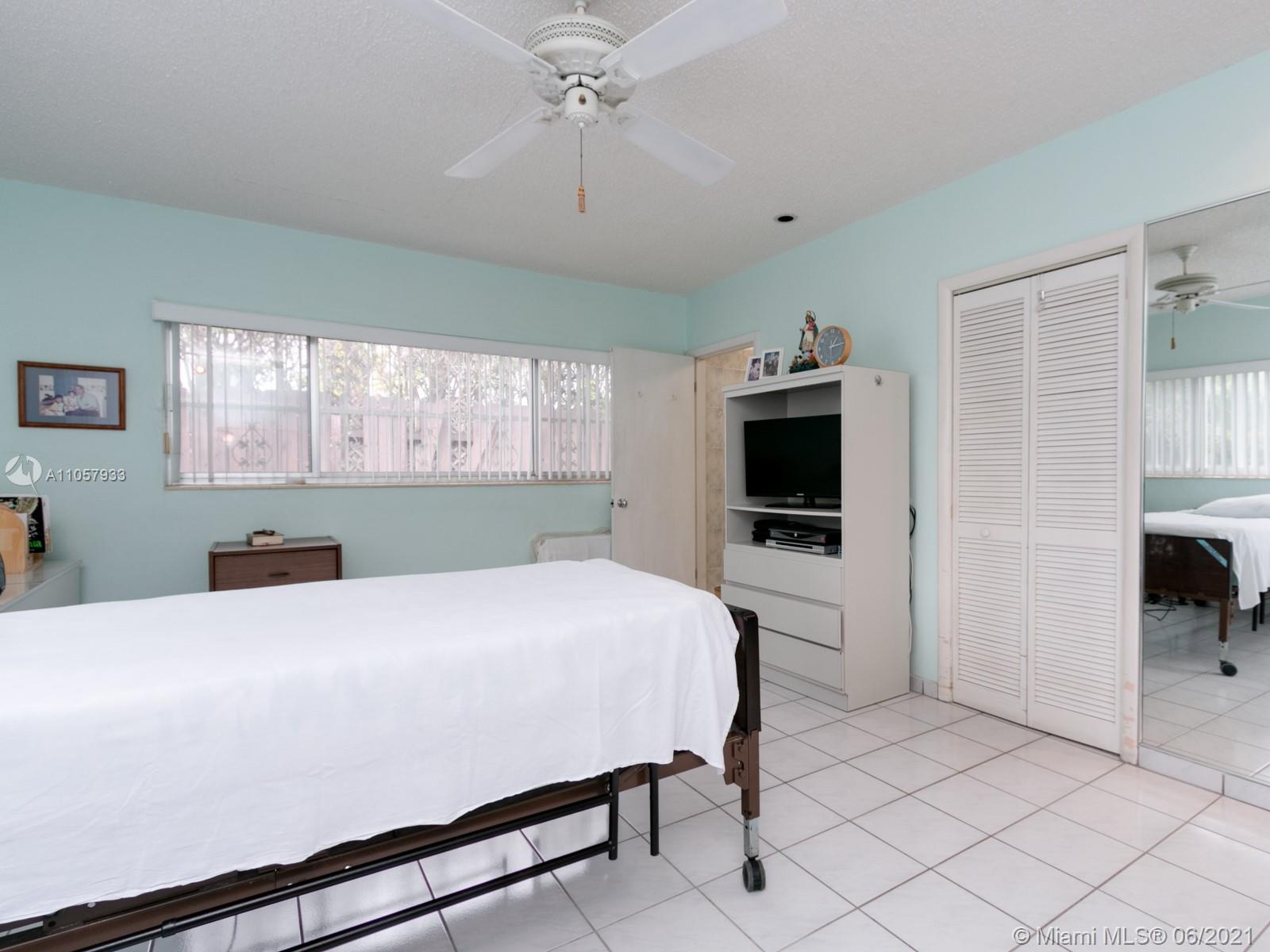 4708 Alton Road Miami Beach, FL 33140 - Photo 9 of 38 a room with a bed a television and a window