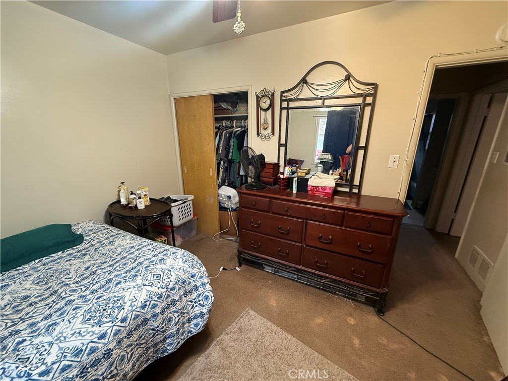 7457 Mt Vernon Street Riverside, CA 92504 - Photo 18 of 23 a bedroom with a bed and a mirror on dresser