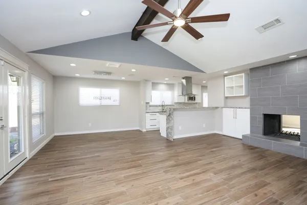 a large kitchen with granite countertop a sink stove and cabinets