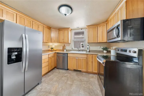 a kitchen with stainless steel appliances a stove microwave and refrigerator