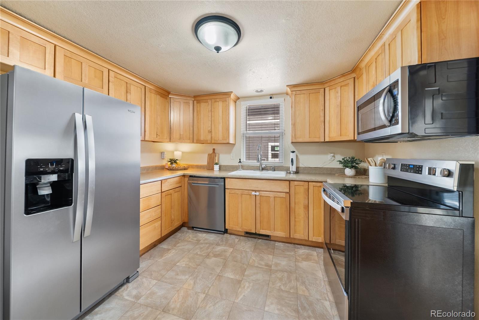 550 Custer Avenue Akron, CO 80720 - Photo 16 of 35 a kitchen with stainless steel appliances granite countertop a refrigerator sink and stove