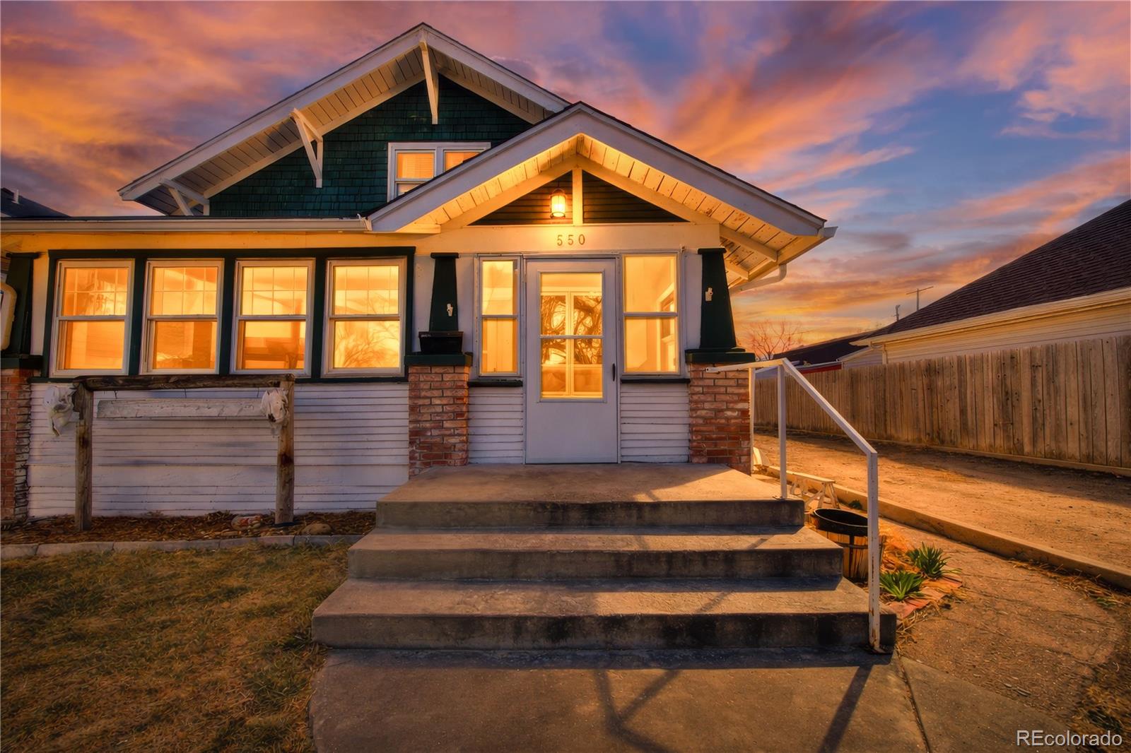 550 Custer Avenue Akron, CO 80720 - Photo 2 of 35 a front view of a house with wooden stairs and a bench