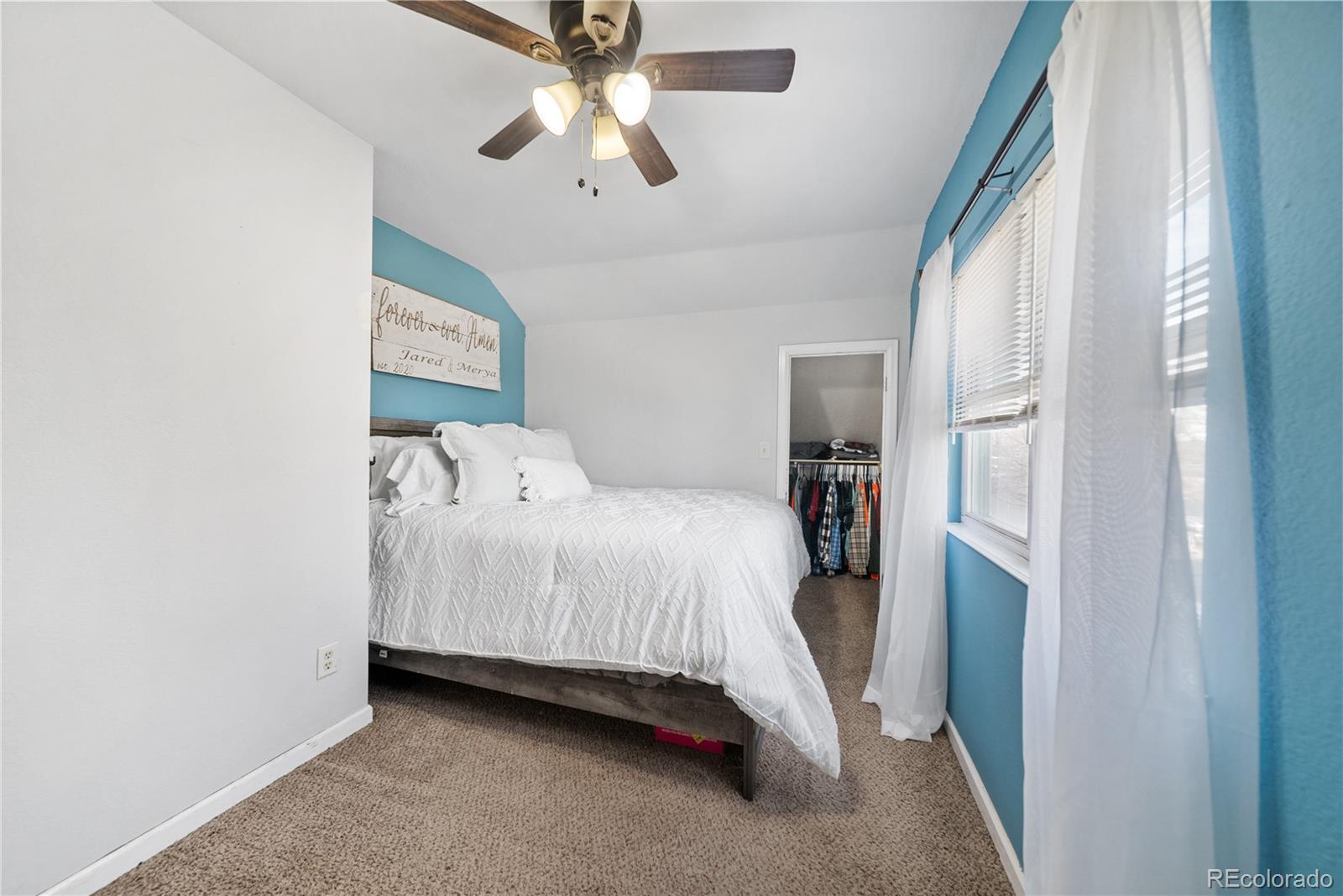 550 Custer Avenue Akron, CO 80720 - Photo 27 of 35 a bedroom with a bed and a chandelier