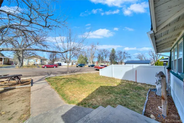 a view of a house with a yard and car parked