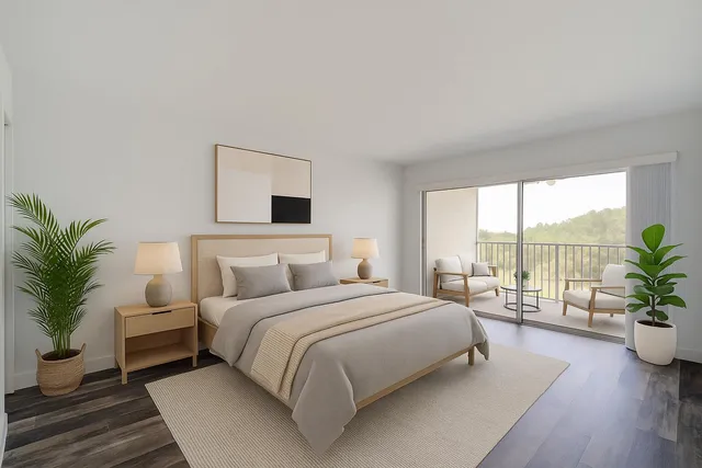 a bedroom with a large bed and a potted plant