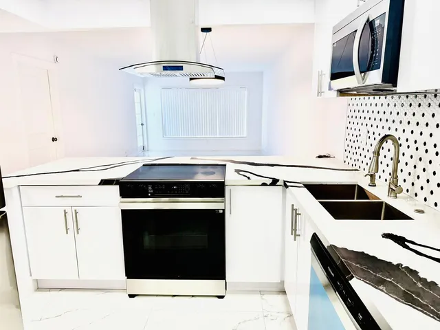 a kitchen with granite countertop a stove and a sink