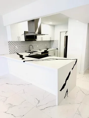 a kitchen with a sink a stove and white cabinets