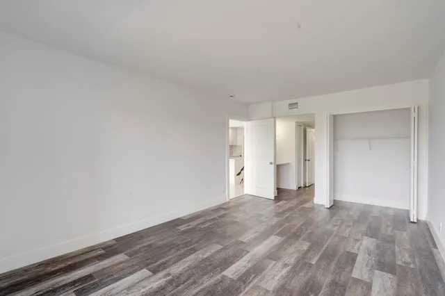 a view of an empty room with wooden floor