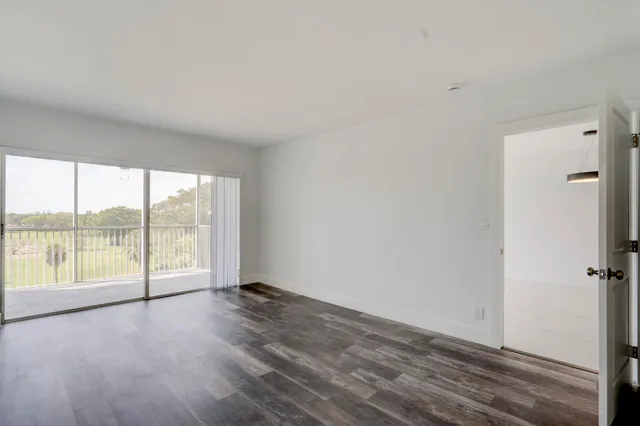 an empty room with wooden floor and sliding door