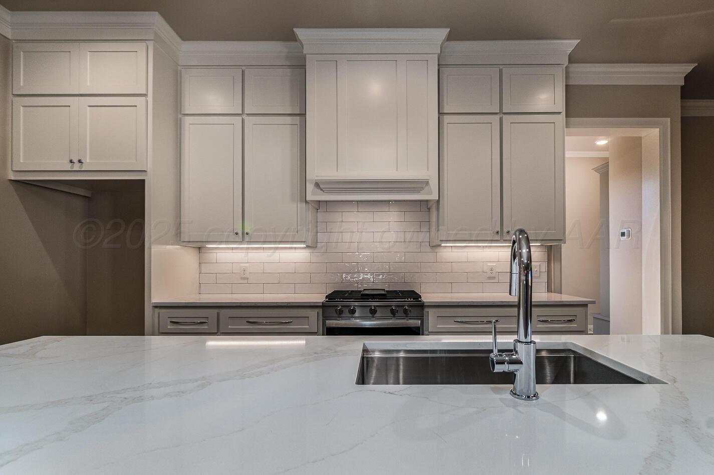 6304 Lauren Ashleigh Drive Amarillo, TX 79119 - Photo 14 of 38 a kitchen with a refrigerator and white cabinets