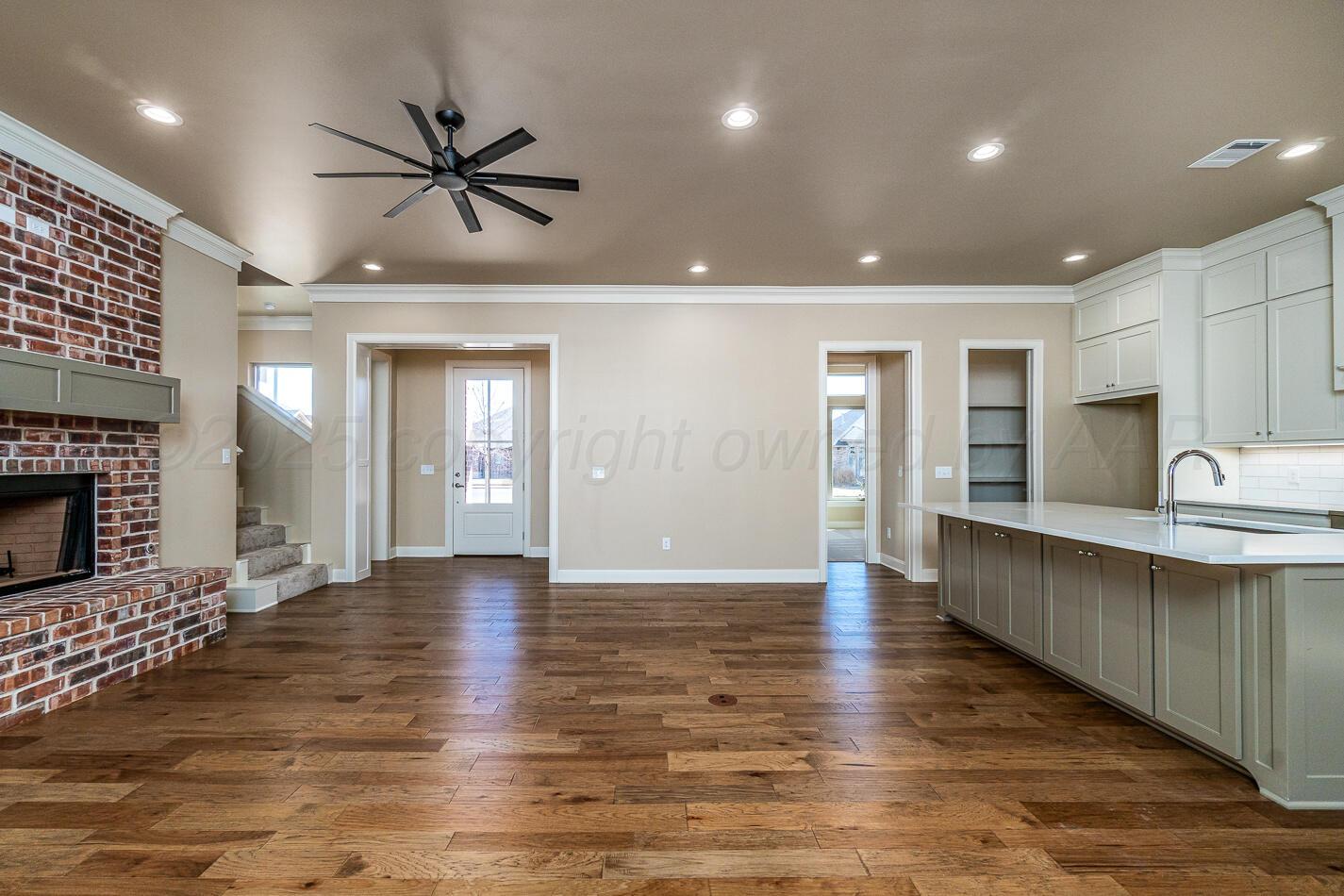 6304 Lauren Ashleigh Drive Amarillo, TX 79119 - Photo 5 of 38 a view of an empty room and kitchen with fireplace ceiling fan