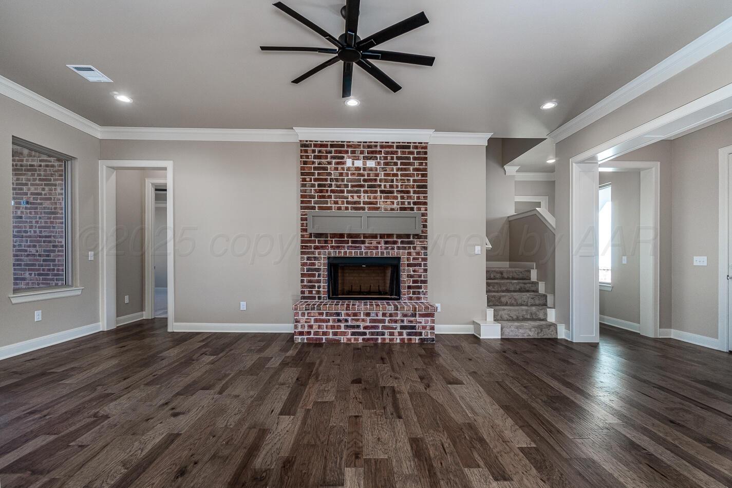 6304 Lauren Ashleigh Drive Amarillo, TX 79119 - Photo 6 of 38 a view of an empty room with wooden floor a fireplace and a window