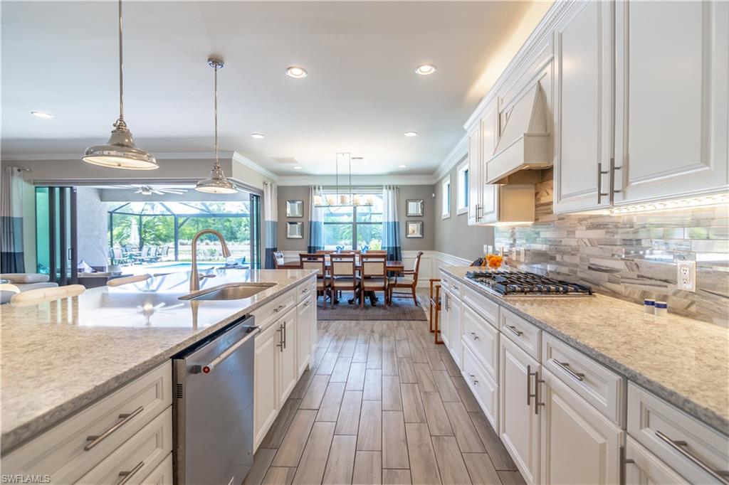 7247 Clamshell Lane Naples, FL 34114 - Photo 12 of 33 a kitchen with stainless steel appliances granite countertop sink a stove and a wooden floors