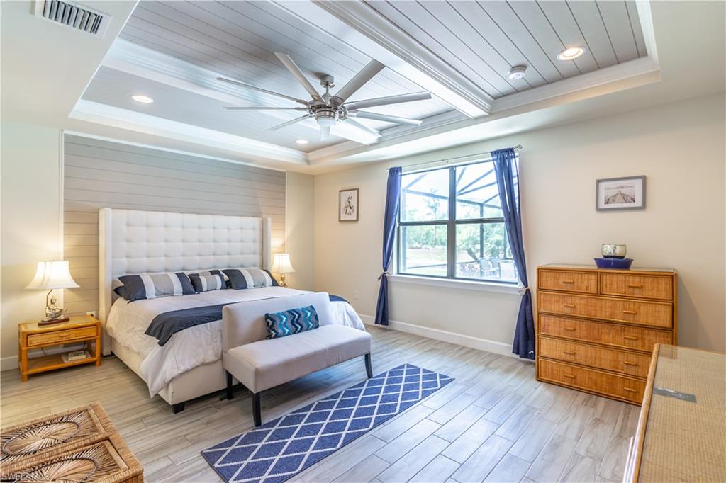 7247 Clamshell Lane Naples, FL 34114 - Photo 16 of 33 a bedroom with a bed and wooden floor