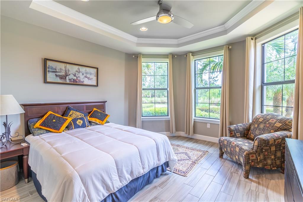 7247 Clamshell Lane Naples, FL 34114 - Photo 18 of 33 a bedroom with a bed and wooden floor