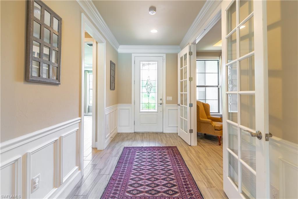 7247 Clamshell Lane Naples, FL 34114 - Photo 20 of 33 a hallway with wooden floor and windows