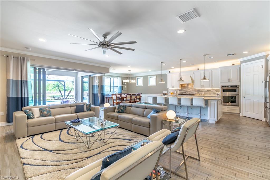 7247 Clamshell Lane Naples, FL 34114 - Photo 8 of 33 a living room with furniture and a large window with wooden floor