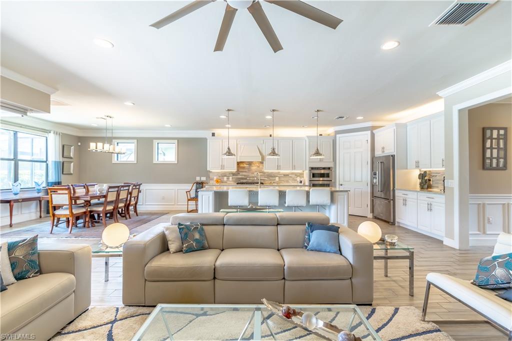 7247 Clamshell Lane Naples, FL 34114 - Photo 9 of 33 a living room with furniture kitchen view and a wooden floor