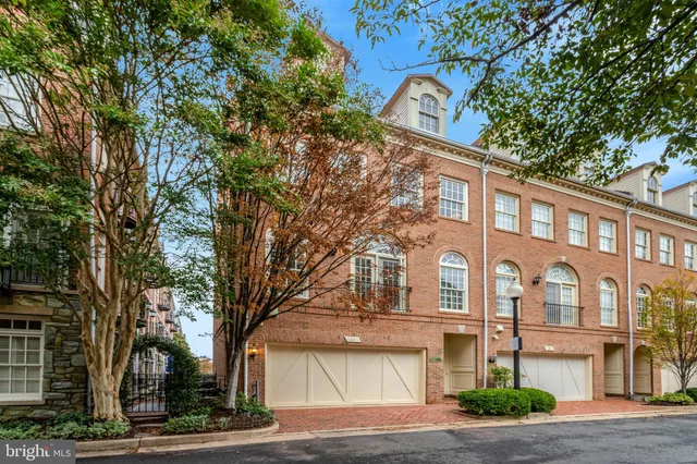 a front view of a building with lot of trees