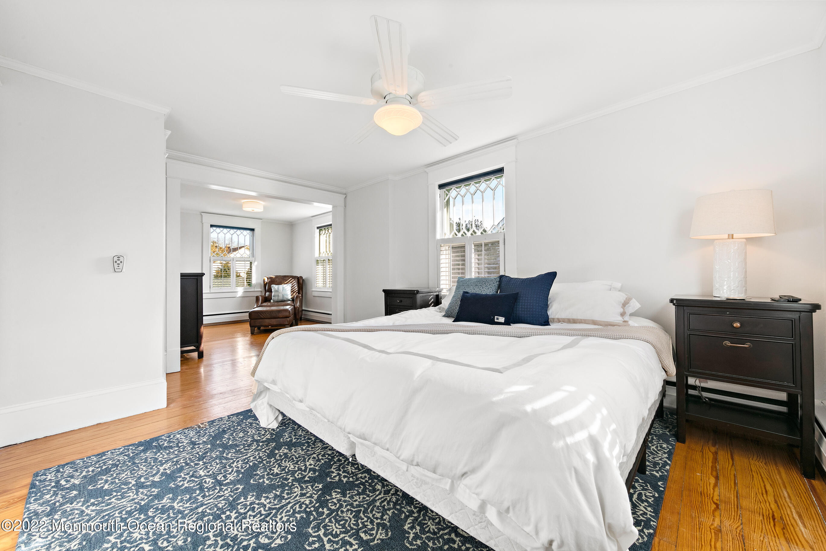 116 Tuttle Avenue, Unit WINTER 20232024 Spring Lake, NJ 07762 - Photo 23 of 44 a bed room with a bed and a chandelier